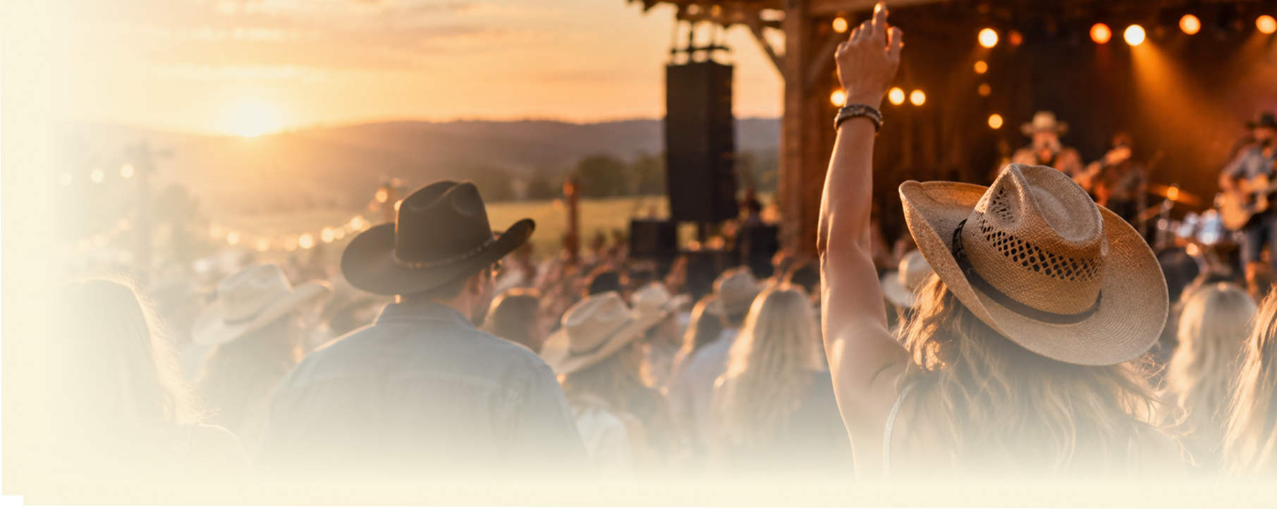 Country music fans in cowboy hats watching an outdoor live music performance at sunset